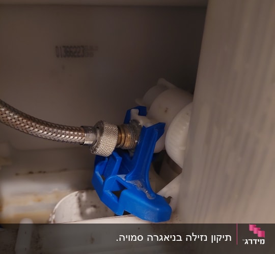 צינור מתכת מחובר למתקן פלסטיק כחול